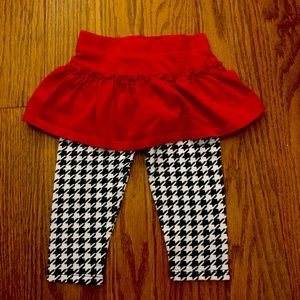Red cloth tutu attached to black and white pattern leggings